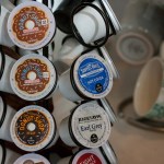 A close-up of various coffee pods (K-Cups) and a decorative ceramic mug, highlighting the office's refreshment amenities