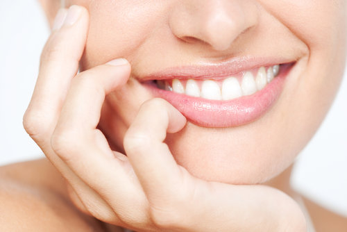 Closeup of a smile with hand