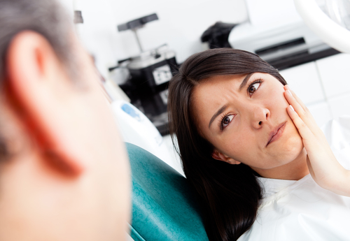Patient holding her cheek in pain